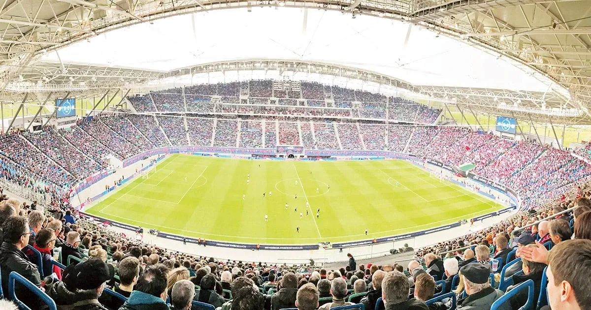 Bầu không khí cuồng nhiệt trên khán đài một trận đấu Bundesliga với cờ và biểu ngữ của các cổ động viên